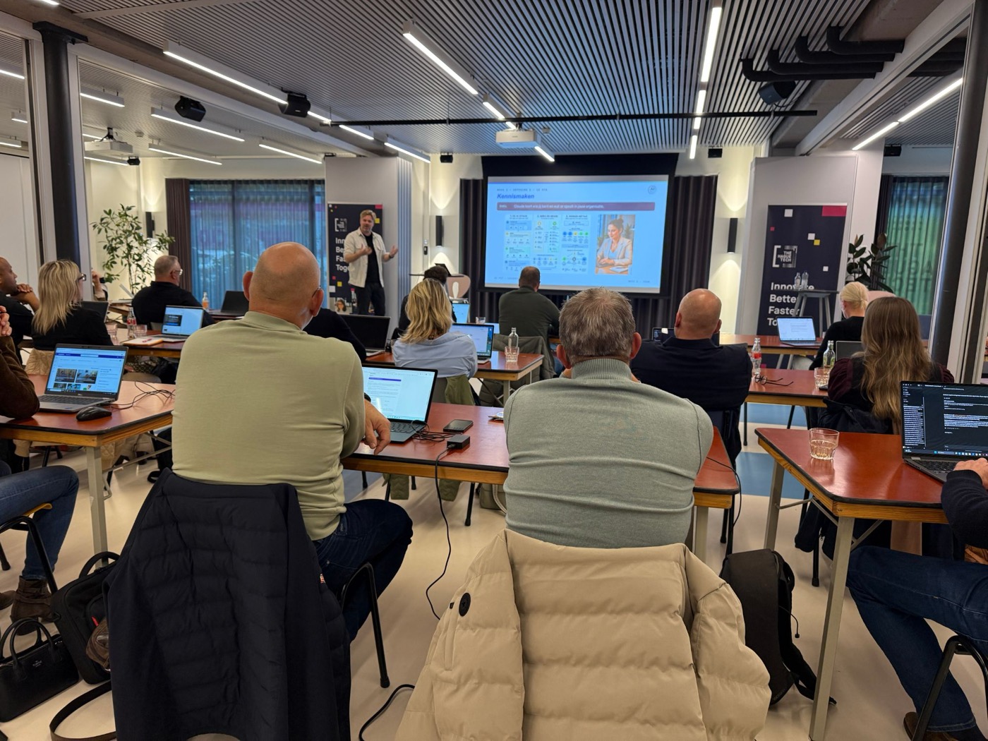 Deelnemers met laptops volgen een AI FiT-training bij The Hague Tech in Den Haag