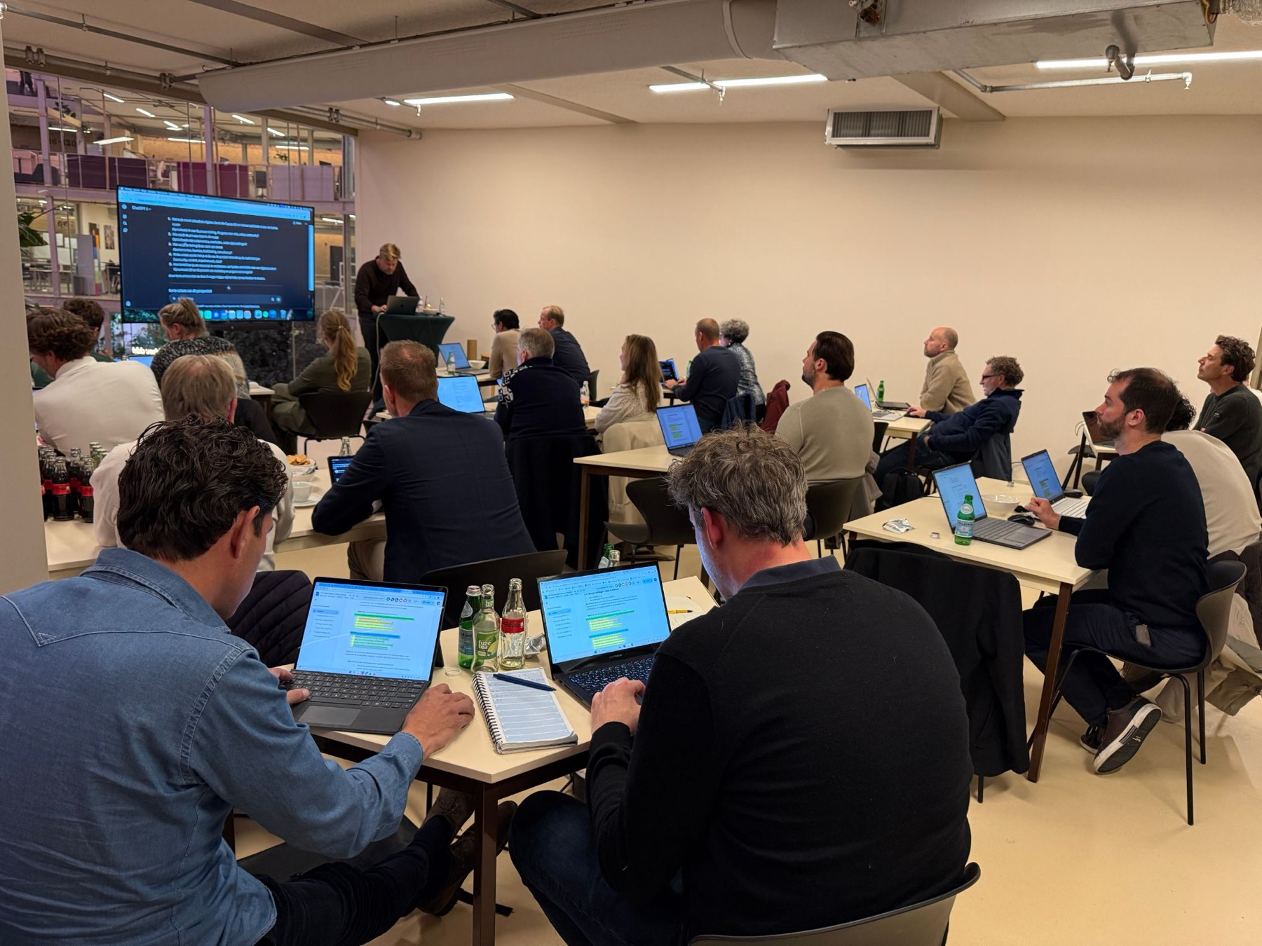 Volle zaal met deelnemers aan laptops tijdens een AI FiT Crash Course